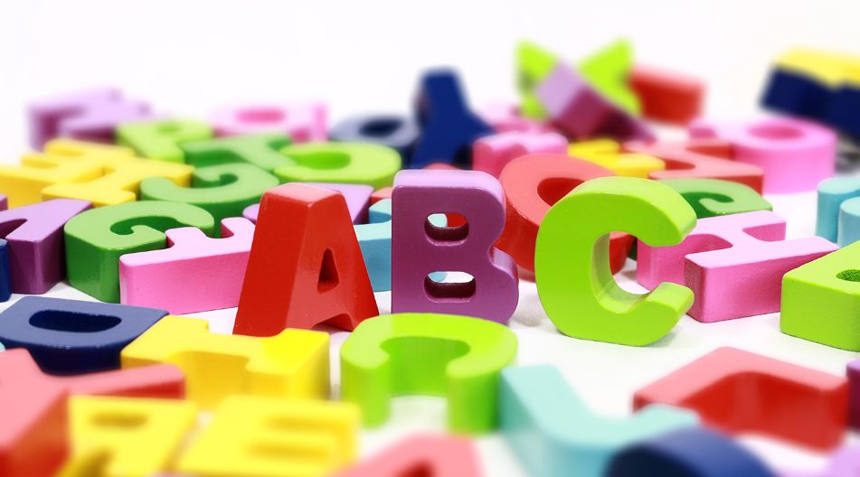 Bunte, plastische Buchstaben und Zahlen liegen verstreut auf einer weißen Oberfläche, mit den Buchstaben "A", "B" und "C" im Fokus. Bunte, plastische Buchstaben und Zahlen liegen verstreut auf einer weißen Oberfläche, mit den Buchstaben "A", "B" und "C" im Fokus.