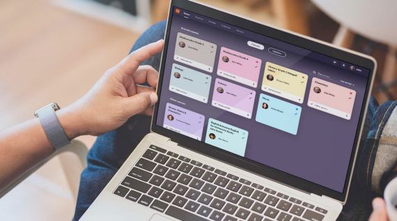 itsLearning benutzen Eine Person arbeitet an einem Laptop, der mit bunten Haftnotizen bedeckt ist.