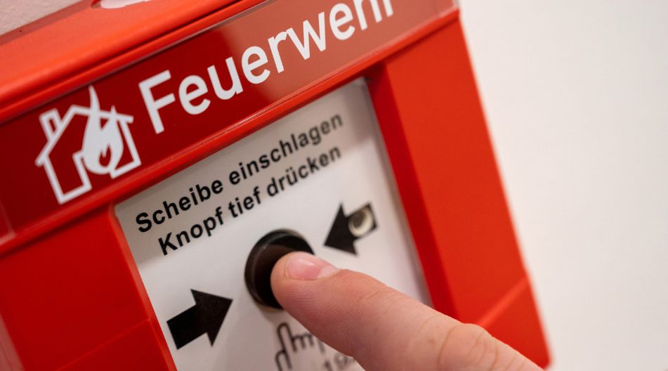Ein Finger betätigt den Notknopf zum Rufen der Feuerwehr. Ein Finger betätigt den Notknopf zum Rufen der Feuerwehr.
