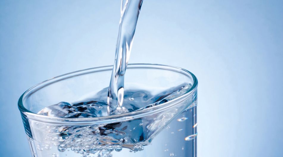 Ein Wasserglas in das gerade Wasser eingegossen wird. Ein Wasserglas in das gerade Wasser eingegossen wird.