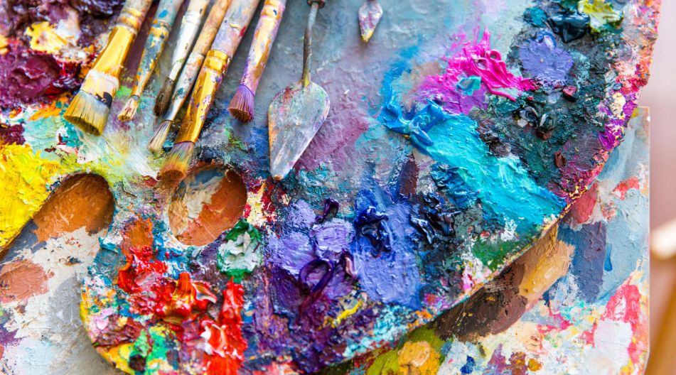 Pinsel und Farben auf einer Palette liegen auf einem Tisch, ideal für künstlerische Arbeiten. Pinsel und Farben auf einer Palette liegen auf einem Tisch, ideal für künstlerische Arbeiten.