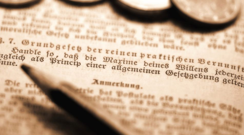 Nahaufnahme einer Münze und eines Stifts auf dem Buch vom Immanuel Kant "Kritik der praktischen Vernunft". Zu sehen ist der Kategorische Imperativ. Nahaufnahme einer Münze und eines Stifts auf dem Buch vom Immanuel Kant "Kritik der praktischen Vernunft". Zu sehen ist der Kategorische Imperativ.