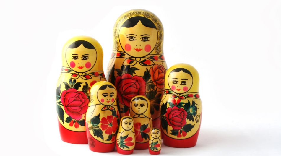 Eine Gruppe russischer Matroschka-Puppen in Rot- und Goldtönen, die traditionelles Handwerk repräsentieren. Eine Gruppe russischer Matroschka-Puppen in Rot- und Goldtönen, die traditionelles Handwerk repräsentieren.