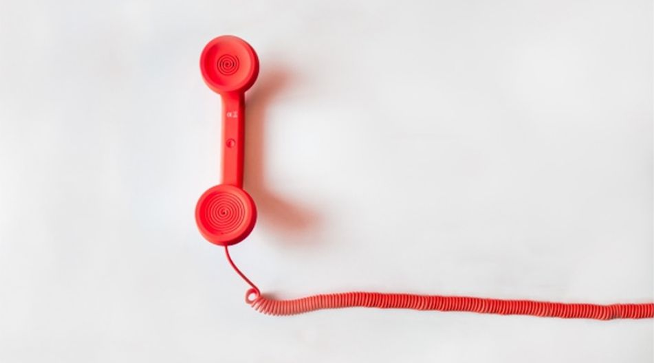 Roter Retro-Telefonhörer mit aufgewickelter Schnur